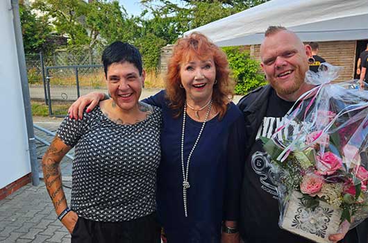 Das Bild zeigt die Inhaber des Pflegeteam Behrens in gelassener Stimmung auf ihrem Sommerfest mit einer Gästin.